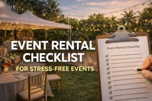 A clipboard with a checklist titled "Event Rental Checklist" is being held by a hand, with several items checked off. In the background, an outdoor event setup with tables, chairs, flowers, and string lights under a tent is visible, creating a beautiful, stress-free atmosphere.